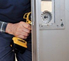 a man making a hole in a door using tool